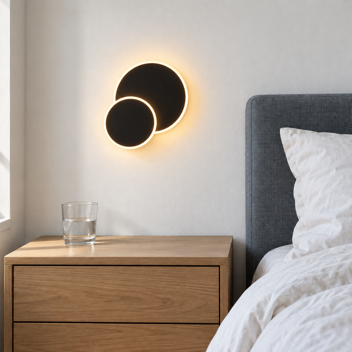 Applique murale Éclipse LED noire allumée dans une chambre